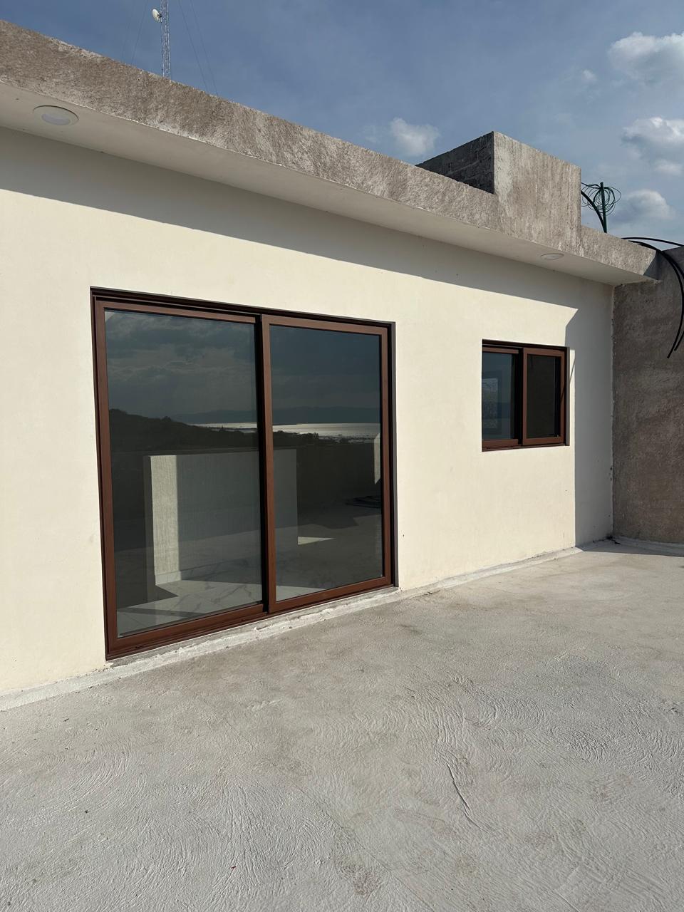 Casa VL — ventana corredera de gran formato en aluminio acabado Nogal Texturizado